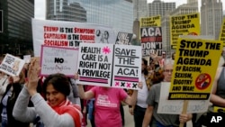Protesters gather across the Chicago River from Trump Tower to rally against the repeal of the Affordable Care Act Friday, March 24, 2017, in Chicago.