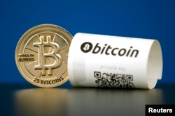 FILE - A Bitcoin (virtual currency) paper wallet with QR codes and a coin are seen in an illustration picture taken at La Maison du Bitcoin in Paris, France, May 27, 2015.