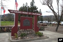 Media trucks set up at the entrance to the Veterans Home of California in Yountville, California, March 9, 2018.