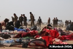U.S.-backed Syrian soldiers escort women from the war zones to refugee camps, stopping at transit centers like this one to be checked for weapons. Men are checked more thoroughly, near Baghuz, Syria, Feb. 26, 2019. (H.Murdoc