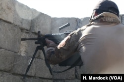 An Iraqi soldiers fires at a nearby house they believe IS may be planning to attack from on Nov. 19, 2016 in Mosul, Iraq.