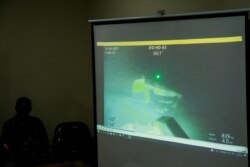 Personel militer menayangkan video yang diyakini sebagai kapal selam TNI AL KRI Nanggala-402 yang tenggelam saat jumpa pers di Bandara I Gusti Ngurah Rai, Bali, 25 April 2021. (Foto: Antara/Fikri Yusuf via REUTERS)