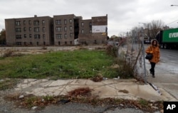 A pedestrian walks past an abandoned lot on a street on the South Side of Chicago that is part of the 6th Police District. Officers there marked a milestone this fall when they recovered their 1,000th gun for the year.