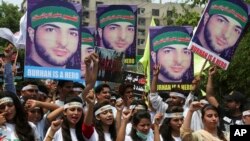 Members of a Kashmiri youth group hold posters of young rebel leader Burhan Wani, killed by Indian troops last year, while chanting anti-Indian slogans during a rally to mark the first anniversary of his death, in Lahore, Pakistan, July 8, 2017.