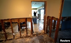 A man tears out Hurricane Harvey flood damage from a home in southwestern Houston, Texas, Sept. 2, 2017.