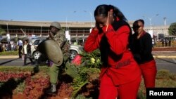 Wafanyakazi wa shirika la ndege la Kenya wakitawanywa na askari wa kikosi cha kuzuia ghasia katika uwanja wa ndege wa Jomo Kenyatta International Airport,Nairobi, Kenya, March 6, 2019.
