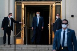 FILE - President Donald Trump walks out of Walter Reed National Military Medical Center after receiving treatment as a COVID-19 patient, in Bethesda, Maryland, Oct. 5, 2020.