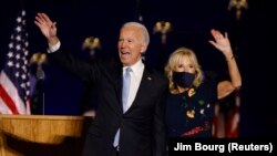 Le candidat démocrate à la présidentielle américaine, Joe Biden et son épouse saluent la foule, à Wilmington, Delaware le 7 novembre, 2020 après que les médias ont annoncé que Biden avait remporté l'élection de 2020 contre le président Trump, . REUTERS /Jim Bourg