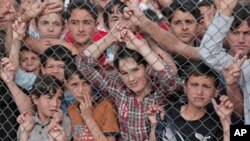 Des migrants derrière des barbelés au camp de réfugiés de Nizip à Gaziantep, Turquie, le 23 avril 2016. 