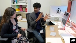 Post-doctoral researcher Tofunmi Omiye, right, gestures while talking in his office with assistant professor Roxana Daneshjou at the Stanford School of Medicine in Stanford, Calif., Tuesday, Oct. 17, 2023. (AP Photo/Eric Risberg)