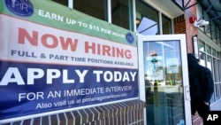 រូបឯកសារ៖ បុរស​ម្នាក់​ដើរ​ចូល​ទៅ​ក្នុង​ភោជនីយដ្ឋាន​មួយ ដែល​មាន​ដាក់​ស្លាកសញ្ញា​ជ្រើសរើស​បុគ្គលិក នៅ​ក្រុង Salem រដ្ឋ New Hampshire សហរដ្ឋ​អាមេរិក ថ្ងៃទី៤ ខែមីនា ឆ្នាំ២០២១។