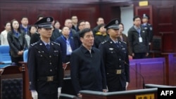 Mantan ketua Asosiasi Sepak Bolah China, Chen Xuyuan (tengah), beridir saat hadir dalam persidangan kasus yang menjeratnya di Pengadilan Huangshi, Hubei, pada 26 Maret 2024. (Foto: Handout/Huangshi Intermediate People's Court/AFP)