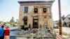 FILE - Pedestrians stop to examine a crumbling building facade in Napa, California, following an earthquake, Aug. 24, 2014. 