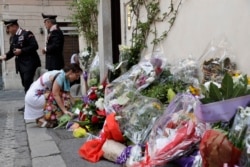 A woman leaves flowers in front of the Carabinieri station where Mario Cerciello Rega was based, in Rome, Italy, July 27, 2019.