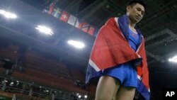 15일 브라질 리우올림픽 남자 기계체조 도마에서 금메달을 차지한 북한 리세광 선수가 우승이 확정된 후 북한 국기인 인공기를 몸에 두르고 있다.