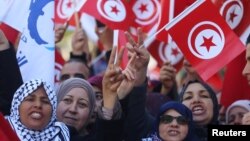 People wave national flags during demonstrations on the seventh anniversary of the toppling of president Zine El-Abidine Ben Ali, in Tunis, Jan. 14, 2018.