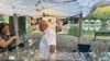 Haydar Serezli, right, speaks to a walk-up customer at his booth at the Festival In the Park in Charlotte, North Carolina, on Sept. 25, 2021. (Salim Fayeq/VOA)