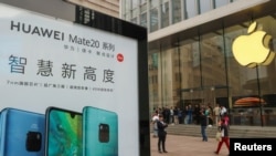 Papan iklan di depan gerai Apple di Shanghai, China, menampilkan telpon genggam Huawei Mate 20, 26 Oktober 2018. (Foto: dok).