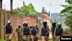 Ugandan riot police patrol an area near the house of presidential candidate and singer Robert Kyagulanyi Ssentamu, known as Bobi Wine, in the Magere neighborhood of Kampala, Uganda, Jan. 16, 2021.