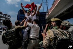 Indian policemen detain Kashmiri Shiite Muslims for participating in a religious procession during restrictions in Srinagar, Indian controlled Kashmir, Sunday, Aug. 7, 2022. Authorities had imposed restrictions in parts of Srinagar, the region's main city, to prevent gatherings marking Muharram from developing into anti-India protests. (AP Photo/Mukhtar Khan)