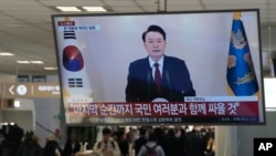 Sebuah layar TV di terminal bus di Seoul sedang menayang Presiden Korea Selatan Yoon Suk Yeoil membacakan pidato pada Kamis, 12 Desember 2024. (Foto: Ahn Young-Joon)