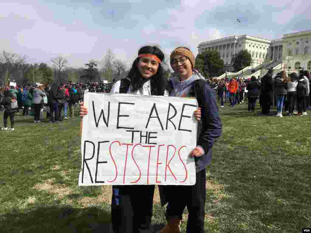 សិស្ស​វិទ្យាល័យ​២​នាក់​កាន់​បដា​ដែល​មាន​ន័យ​ថា​&laquo;យើង​ជា​បង​ប្អូន​ស្រី​២នាក់​ដែល​តស៊ូ&raquo; នៅ​ពេល​ដែល​ពួកគេ​ចូលរួម​ក្នុង​ការ​ដើរ​ចេញ​ពី​ថ្នាក់​រៀន​នៅ​ព្រឹក​ថ្ងៃ​ពុធ ទី​១៤​ខែមីនា ឆ្នាំ​២០១៨ ដើម្បី​តវ៉ា​ប្រឆាំង​នឹង​ការ​មិន​ចាត់​វិធានការណ៍​របស់​សភា ដើម្បី​បំបាត់​អំពើ​ហិង្សា​ដោយ​ការ​ប្រើ​ប្រាស់​កាំភ្លើង ក្នុង​សាលា​រៀន​នៅ​សហរដ្ឋ​អាមេរិក។ (ប៉ូច រាសី/VOA)