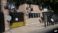 Members of the media take pictures of the damage to a security booth by a shot fired, outside the U.S. Embassy in Ankara, Turkey, Aug. 20, 2018.