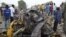 People look at damage in a market area after a bomb explosion in Ajilari-Gomari near the city's airport, Maiduguri, Borno State, March 2, 2014.