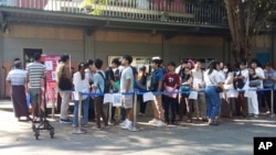 FILE - People wait in line to enter the Thai Embassy for visas in Yangon, Myanmar, on Feb. 20, 2024. Crowds of people have thronged to get passports and visas to neighboring Thailand since the government activated a law making 14 million young people subject to conscription.