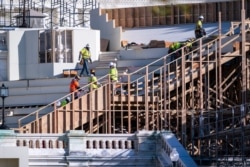 FILE - Construction crews work on the platforms where the president-elect will take the oath of office, at the Capitol in Washington, Nov. 18, 2020. (AP Photo/J. Scott Applewhite)