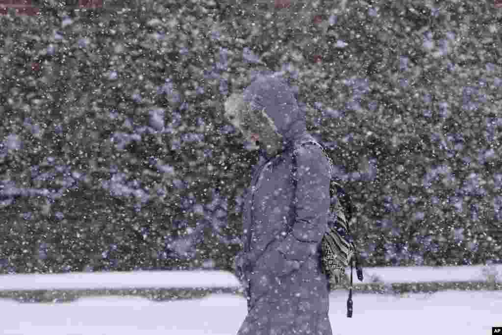 Seorang pejalan kaki berjalan pada saat badai salju melanda kota Philadelphia selatan, negara bagian Pennsylvania, AS. 