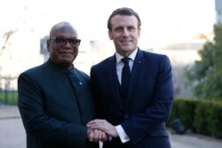 French President Emmanuel Macron, right, greets Mali's President Ibrahim Boubacar Keita prior to a meeting at the G5 Sahel summit in Pau, southwestern France, Jan.13, 2020.