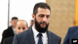 FILE - Syria's de facto leader Ahmad al-Sharaa walks in the presidential palace ahead of a meeting, in Damascus, Dec. 28, 2024.