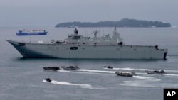 FILE - the Royal Australian Navy HMAS Adelaide cruises alongside landing crafts with Philippine Marines and Australian troops as they conduct a joint Humanitarian Aid and Disaster Relief (HADR) exercise off Subic Bay in northwestern Philippines.