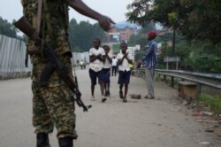 FILE - School-going pupils from the Democratic Republic of Congo cross the Mpondwe border point separating Uganda and the DRC, Aug. 14, 2019.