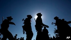 FILE - Ta’ang National Liberation army officers join a traditional line dance with civilians during a celebration in Mar-Wong Village, northern Shan state, Myanmar, marking their insurrection more than a half-century ago, Jan. 12, 2015. 