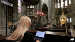 Mahasiswa mengikuti kuliah melalui video stream di gereja neo-gothic 'Votivkirche' di Wina, Austria, Kamis, 15 Oktober 2020. (Foto: AP)