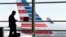 FILE - A passenger talks on the phone as American Airlines jets sit parked at their gates at Washington's Ronald Reagan National Airport, Jan. 25, 2016. A civil rights group is suing the Trump administration for details on how data found by immigration officials on travelers' electronic devices is kept or shared.