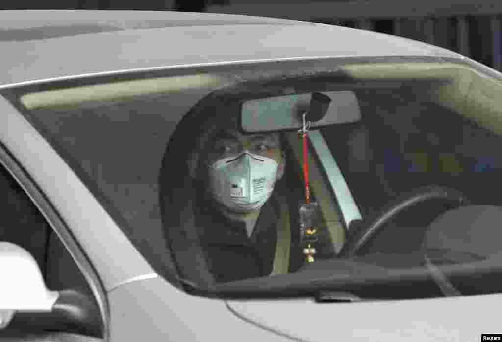 A man wearing a mask drives a car amid thick haze in the morning in Beijing, Feb. 26, 2014.&nbsp;