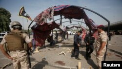 Polisi Irak berkumpul di lokasi bom bunuh diri di Baghdad, Irak, 16 Oktober 2016. 