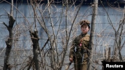 FILE - A North Korean prison policewoman stands guard behind fences at a jail on the banks of Yalu River near the Chongsong county of North Korea, opposite the Chinese border city of Dandong.