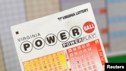 Seorang pria memegang tiket lotre Virginia dengan hadian $400 juta di Arlington, Virginia, 19 February 2014.