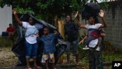 Migrants raise their hands after confronting authorities near Tuzantan, Chiapas state, Mexico, Oct. 12, 2019. Hundreds of migrants were arrested by Mexican authorities as they made their way to Mexico City. 