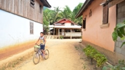 A boy rides his bicycle through Houaygno village, northern Laos, Nov. 4, 2019. (Zsombor Peter/VOA)
