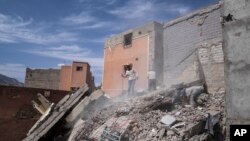 FILE - People dig through rubble as they try to salvage usable belongings and equipment after an earthquake in Amizmiz, outside Marrakech, Morocco, on Oct. 6, 2023.