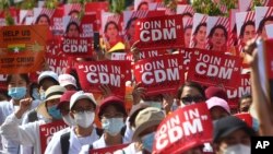 រូបឯកសារ៖ បាតុករ​ប្រឆាំង​នឹង​រដ្ឋប្រហារ​យោធា​កាន់​ផ្ទាំង​បដា​មួយ​ដែល​សរសេរ​ថា៖ «ចូលរួម​ជាមួយ​នឹង​ចលនា​ប្រឆាំង​» ក្នុង​អំឡុងពេល​ធ្វើ​បាតុកម្ម​នៅ​ក្បែរ​ស្ថានីយ៍​រថភ្លើង​ក្នុង​ក្រុង Mandalay ប្រទេស​មីយ៉ាន់ម៉ា ថ្ងៃទី២២ ខែកុម្ភៈ ឆ្នាំ២០២១។ 