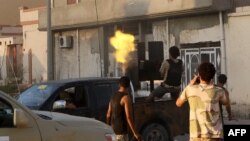 Un membre des forces loyales au Gouvernement libyen soutenu par les Nations Unies (GNA) tire une mitrailleuse près de la zone centrale appelée District One, dans la ville côtière de Syrte, à l'est de la capitale Tripoli, 21 août 2016.