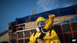 A health worker stands in the Sambadrome as he sprays insecticide to combat the Aedes aegypti mosquitoes that transmit the Zika virus, in Rio de Janeiro, Brazil, Jan. 26, 2016. 