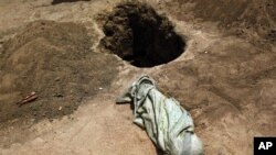 The shrouded body of 12-month-old Liin Muhumed Surow before burial at UNHCR's Ifo Extension camp outside Dadaab, Saturday Aug. 6, 2011. Liin died of malnutrition 25 days after reaching the camp, her father Mumumed said.