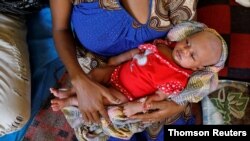 Ethiopian refugee Salam Gberedanos holds her 22-day-old daughter, Abeyam, born while her parents were fleeing fighting in the Tigray region, at the Village 8 refugees transit camp near the Sudan-Ethiopia border Dec. 2, 2020.